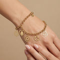 Bracelet chaîne en or jaune 18k à breloques (main de Fatma, soleil, trèfle, rosace) - bijou porté par une mannequin