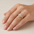 Bague solitaire halo en or jaune 18k - bijou porté par une mannequin