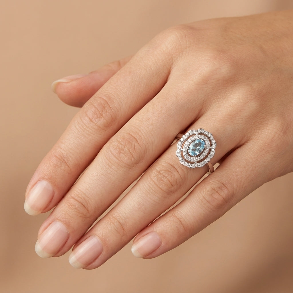 Bague en or blanc 18k pierre bleue halo sertie - bijou porté par une mannequin