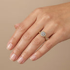 Bague solitaire halo en or jaune 18k - bijou porté par une mannequin