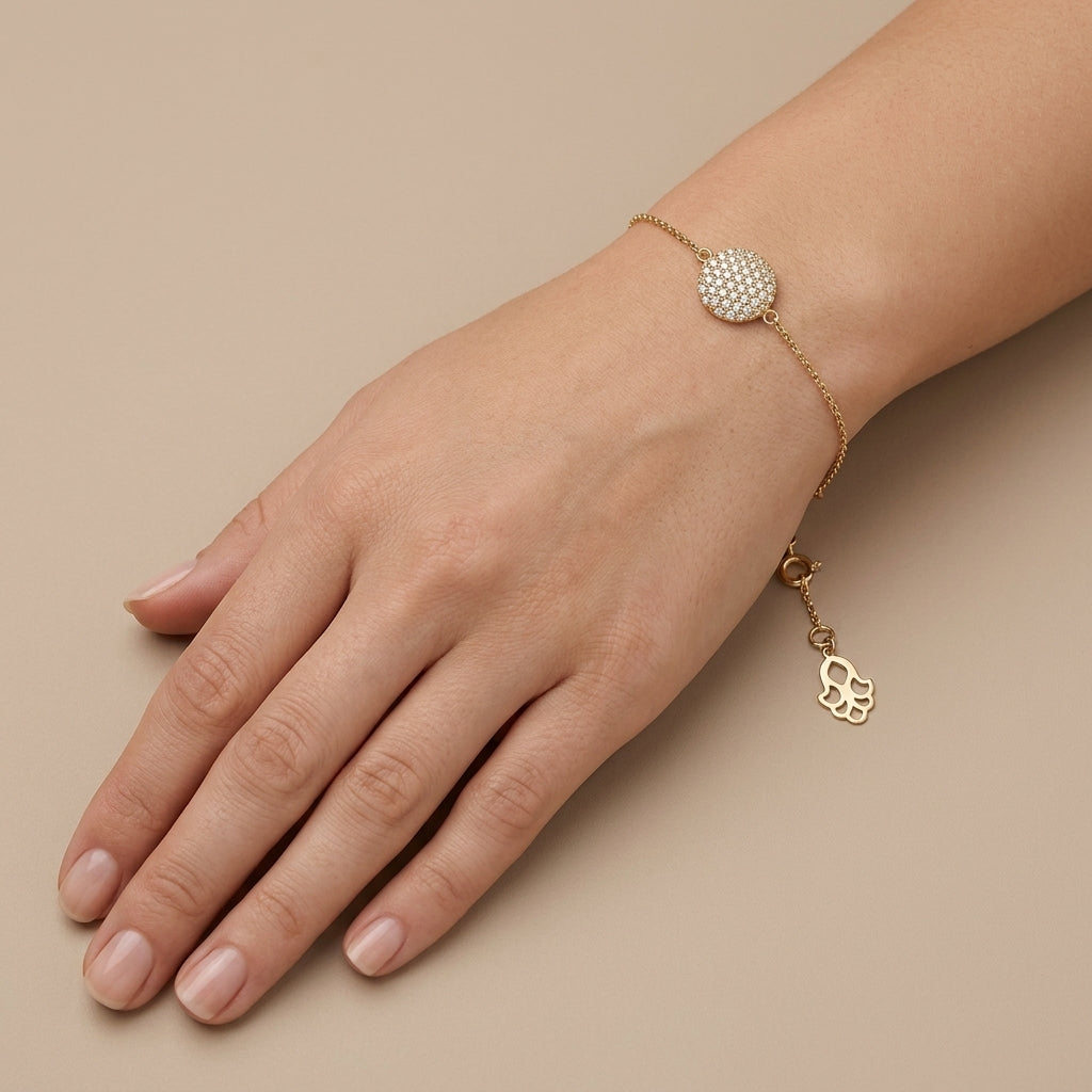 Bracelet chaîne en or jaune 18k pastille ronde pavée de pierres - bijou porté par une mannequin