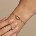Bracelet chaîne en or jaune 18k cauri pavé de pierres - bijou porté par une mannequin