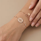 Bracelet chaîne en or rose 18k médaille ronde sertie - bijou porté par une mannequin