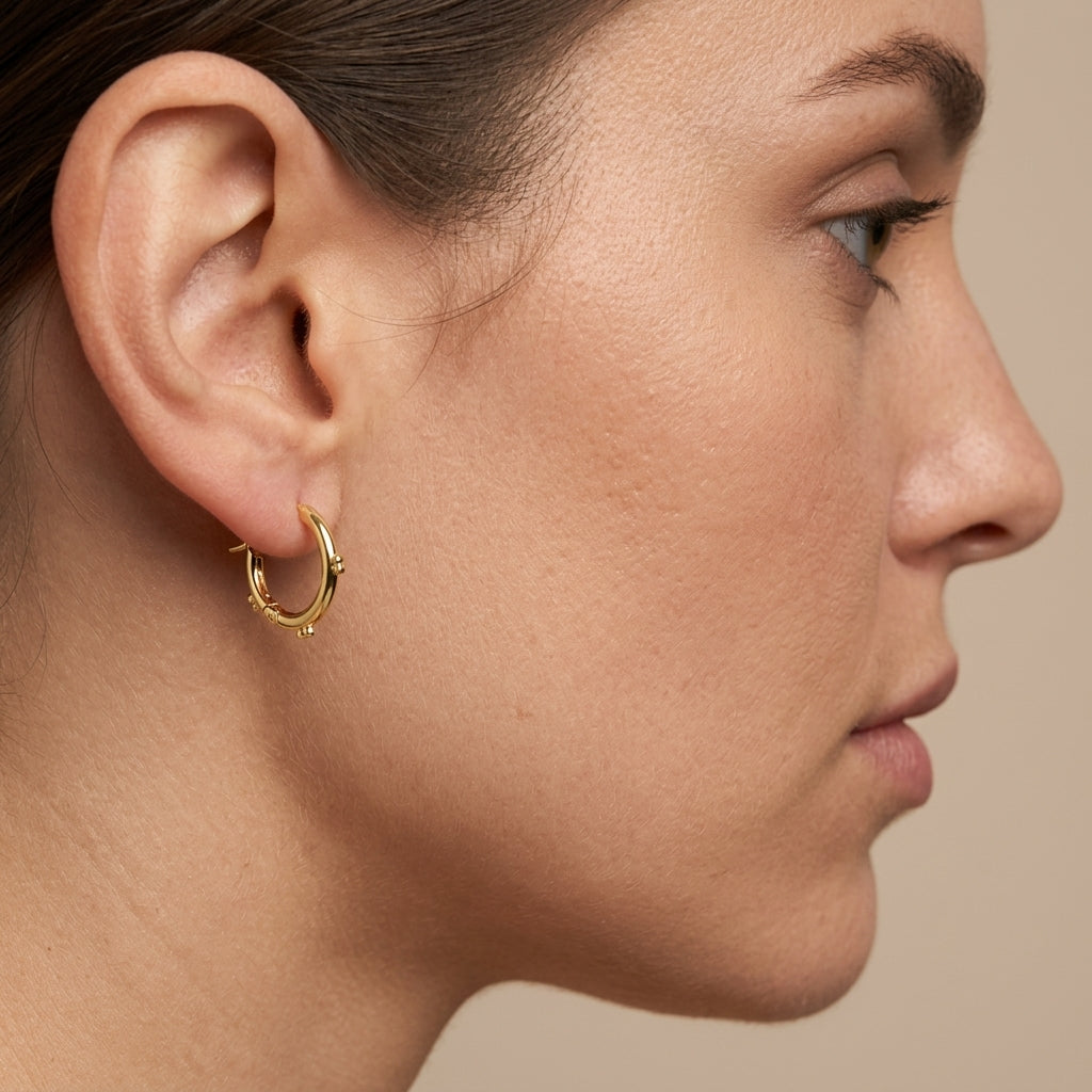 Boucles d'oreilles mini créoles en or jaune 18k - bijou porté par une mannequin