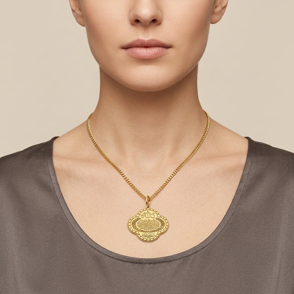 Pendentif médaille ovale en or jaune 18k gravée d'une sourate - bijou porté par une mannequin