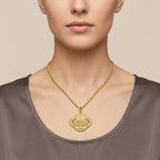 Pendentif médaille ovale en or jaune 18k gravée d'une sourate - bijou porté par une mannequin