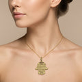 Pendentif main de Fatma en or jaune 18k gravée d'une sourate - bijou porté par une mannequin