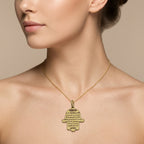 Pendentif main de Fatma en or jaune 18k gravée d'une sourate - bijou porté par une mannequin