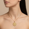 Pendentif médaille ronde ajourée en or jaune 18k gravée d'une sourate - bijou porté par une mannequin