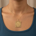 Pendentif plaque carrée ajourée en or jaune 18k gravée d'une sourate - bijou porté par une mannequin