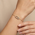 Bracelet chaîne en or jaune 18k plaque ovale sertie, pierre mobile - bijou porté par une mannequin