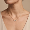 Collier en or jaune 18k pendentif ovale serti, pierre mobile - bijou porté par une mannequin