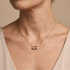 Collier en or jaune 18k pendentif ovale serti, pierre mobile - bijou porté par une mannequin