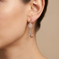 Boucles d'oreilles pendantes en or rose 18k ovales sertis, pierre mobile - bijou porté par une mannequin