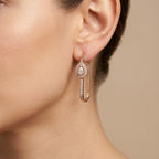 Boucles d'oreilles pendantes en or rose 18k ovales sertis, pierre mobile - bijou porté par une mannequin