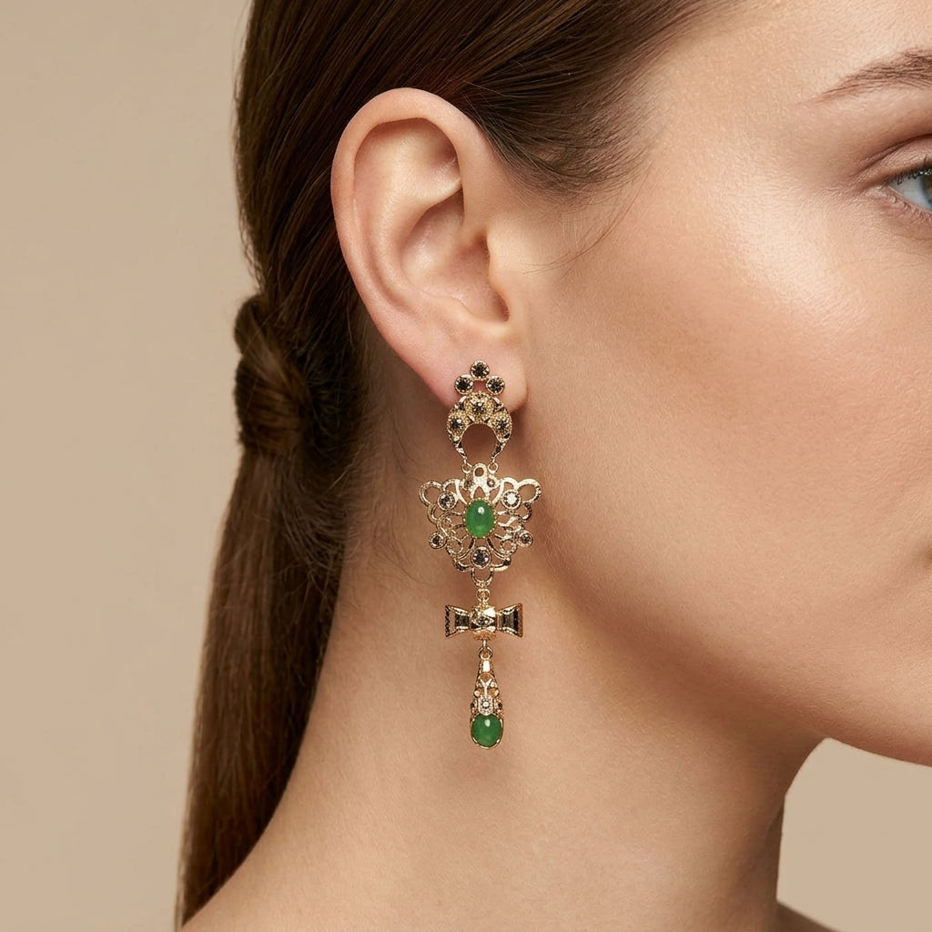 Boucles d'oreilles pendantes beldi rosaces en or rose 18k serties, nœuds et pierres vertes - bijou porté par une mannequin
