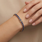 Bracelet rivière en or jaune 18k serti de pierres bleues - bijou porté par une mannequin