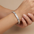 Bracelet jonc vis en or blanc 18k pavé de pierres - bijou porté par une mannequin