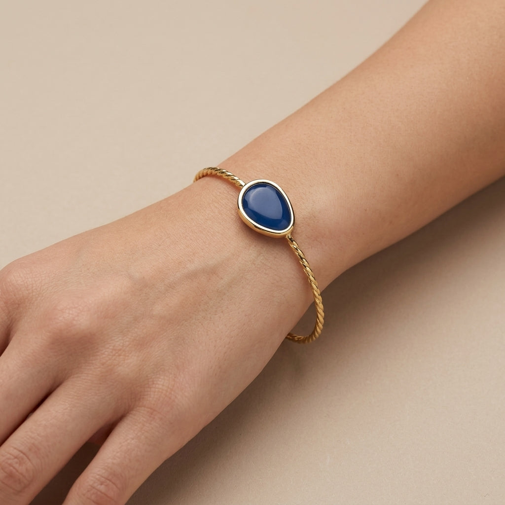 Bracelet jonc ouvert en or jaune 18k pierre bleue cabochon - bijou porté par une mannequin