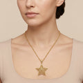 Sautoir en or jaune 18k pendentif étoile ajourée - bijou porté par une mannequin