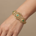 Bracelet jonc beldi rosaces en or jaune 18k serti de pierres, pierres vertes - bijou porté par une mannequin