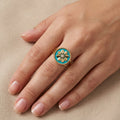 Bague en or jaune 18k fleur émaillée turquoise sertie de pierres - bijou porté par une mannequin