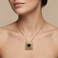 Pendentif beldi carré en or rose 18k serti de pierres, pierre foncée centrale - bijou porté par une mannequin