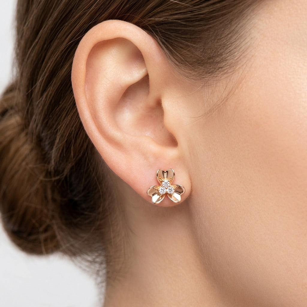 Boucles d'oreilles puces fleurs en or rose 18k serties d'une pierre - bijou porté par une mannequin