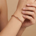 Demlij jonc fin lisse en or rose 18k - bijou porté par une mannequin