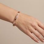 Bracelet jonc plat en or rose 18k serti de pierres - bijou porté par une mannequin