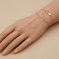 Bracelet-bague en or rose 18k chaîne d'annulaire, pierres en station - bijou porté par une mannequin
