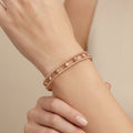 Bracelet jonc double en or rose 18k boules et pierres serties - bijou porté par une mannequin