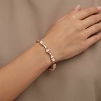 Bracelet jonc maillons en or rose 18k serti de pierres baguettes - bijou porté par une mannequin