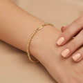 Bracelet boules facettées en or jaune 18k - bijou porté par une mannequin