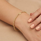 Bracelet boules facettées en or jaune 18k - bijou porté par une mannequin
