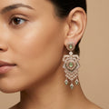 Boucles d'oreilles pendantes beldi ajourées en or rose 18k serties, pierres vertes, pampilles - bijou porté par une mannequin