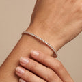 Bracelet jonc fin en or rose 18k serti de pierres - bijou porté par une mannequin