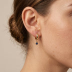 Boucles d'oreilles mini créoles en or jaune 18k pampilles pierres bleues - bijou porté par une mannequin