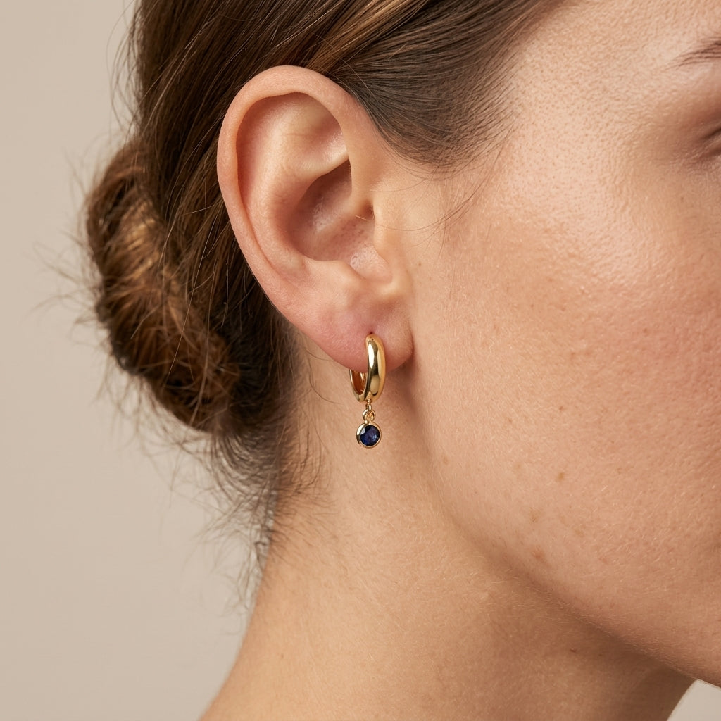 Boucles d'oreilles mini créoles en or jaune 18k pampilles pierres bleues - bijou porté par une mannequin