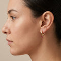 Boucles d'oreilles mini créoles en or jaune 18k pampilles pierres rouges - bijou porté par une mannequin