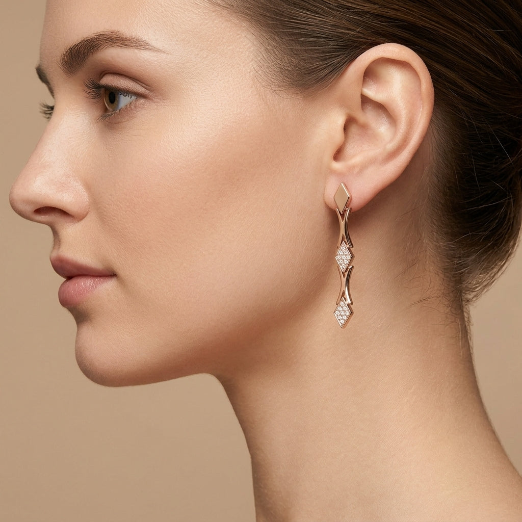 Boucles d'oreilles pendantes en or rose 18k branches serties de pierres - bijou porté par une mannequin