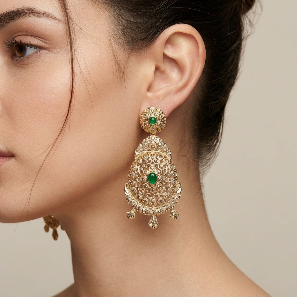 Boucles d'oreilles pendantes beldi gouttes ajourées en or jaune 18k serties, pierres vertes - bijou porté par une mannequin