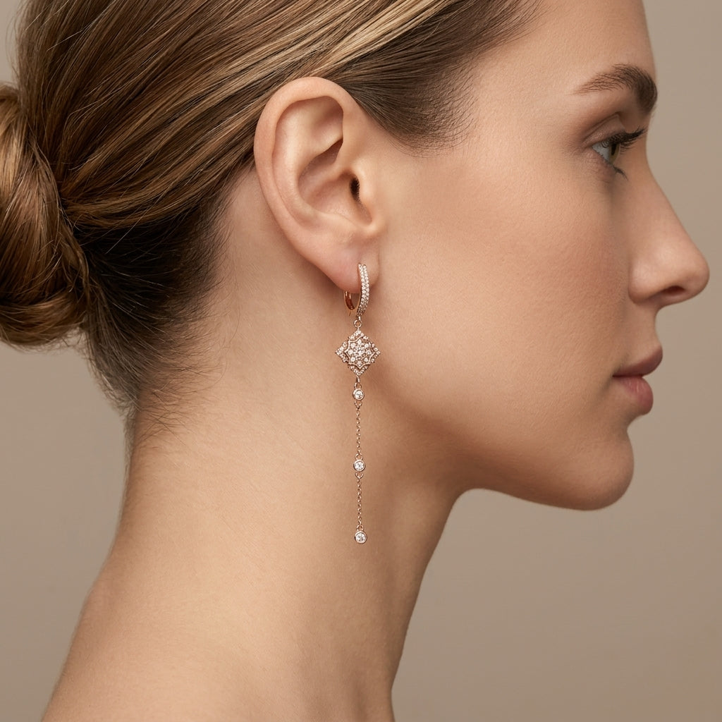 Boucles d'oreilles pendantes en or rose 18k losanges pavés et chaînettes - bijou porté par une mannequin