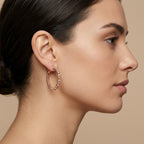 Boucles d'oreilles créoles en or rose 18k serties de pierres, motif torsadé - bijou porté par une mannequin