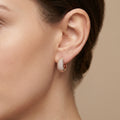 Boucles d'oreilles mini créoles bombées en or rose 18k pavées de pierres - bijou porté par une mannequin