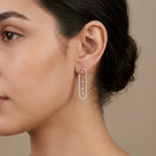 Boucles d'oreilles pendantes en or rose 18k ovales allongés sertis, pierre mobile - bijou porté par une mannequin
