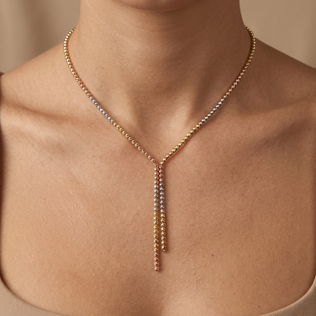 Collier cravate en or jaune 18k boules facettées tricolores - bijou porté par une mannequin