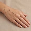 Bracelet-bague en or rose 18k chaîne d'annulaire, pierres en station - bijou porté par une mannequin