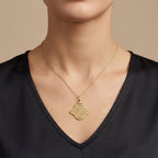 Pendentif khmissa en or jaune 18k gravée d'une sourate - bijou porté par une mannequin