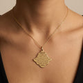Pendentif khmissa en or jaune 18k gravée d'une sourate - bijou porté par une mannequin